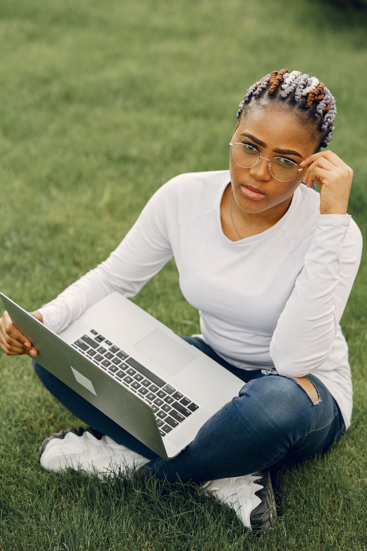 Woman Using Laptop While Sitting On The Ground Outside 