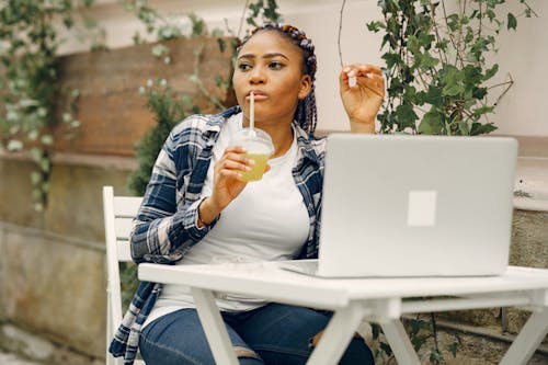 Young Woman Working on Laptop in Cafe Outdoors