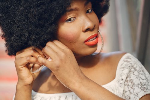 Free Close-Up Photo of a Woman Putting on Her Hoop Earrings Stock Photo