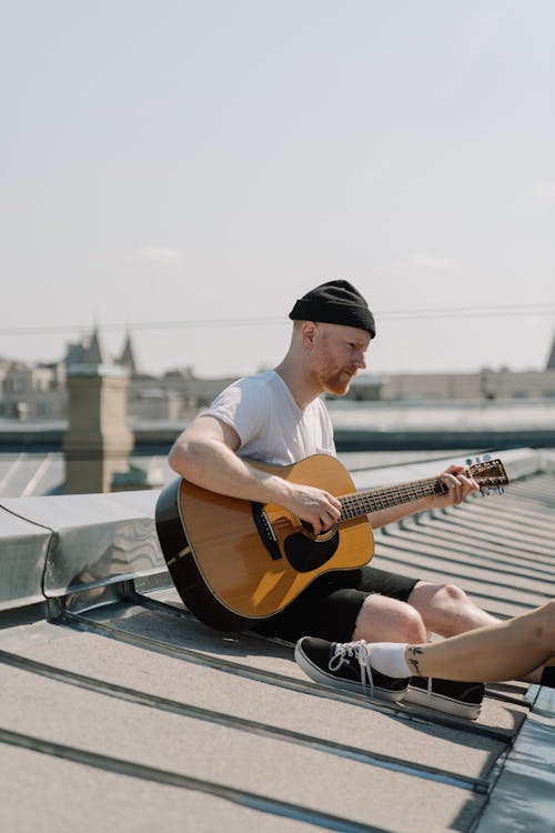 Man in White T-shirt Playing Acoustic Guitar