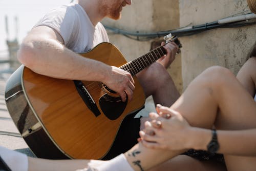 Man in White T-shirt Playing Brown Acoustic Guitar