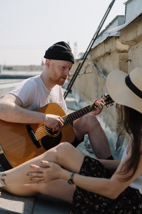 Man in White Crew Neck T-shirt Playing Guitar