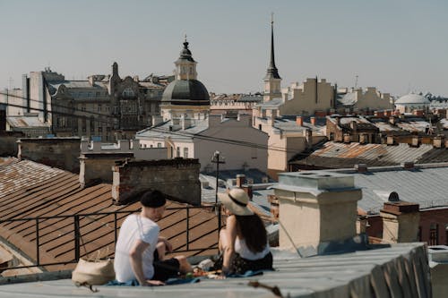 People Sitting on White Concrete Stairs Near Brown Concrete Building