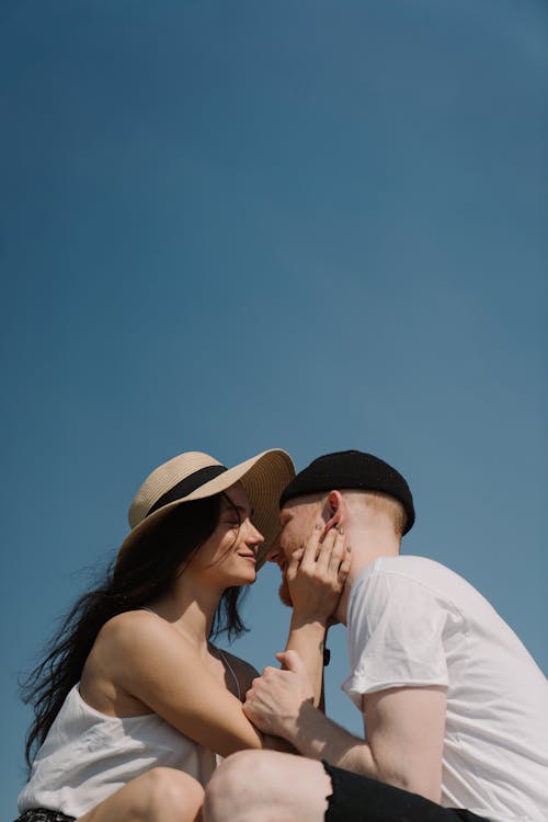 Man in White Shirt Kissing Woman in Black Tank Top