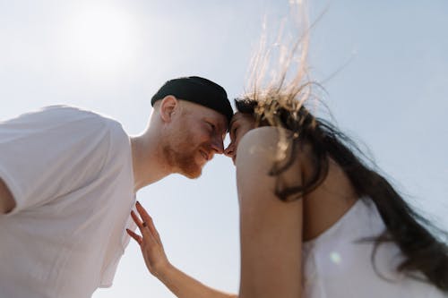 Man in White Shirt Kissing Woman in White Dress