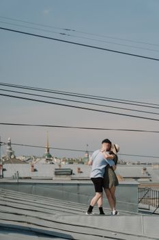 一对年轻夫妇在阳光明媚、能欣赏城市景观的屋顶上，共享浪漫时刻