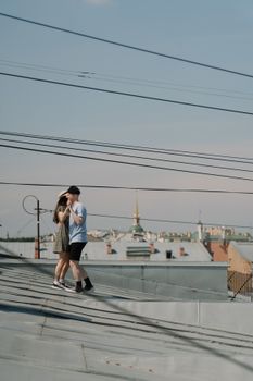一对年轻夫妇在屋顶上，以城市景观为背景，分享浪漫时刻