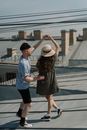 在一个阳光明媚的夏日，一对年轻夫妇在城市屋顶上享受浪漫的舞蹈