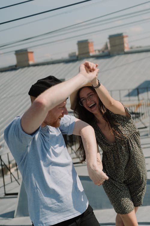 Man in Blue Crew Neck T-shirt Beside Woman in Black and White Sleeveless Dress