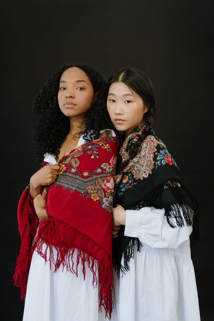 Two women in floral traditional scarves exuding elegance and cultural diversity.