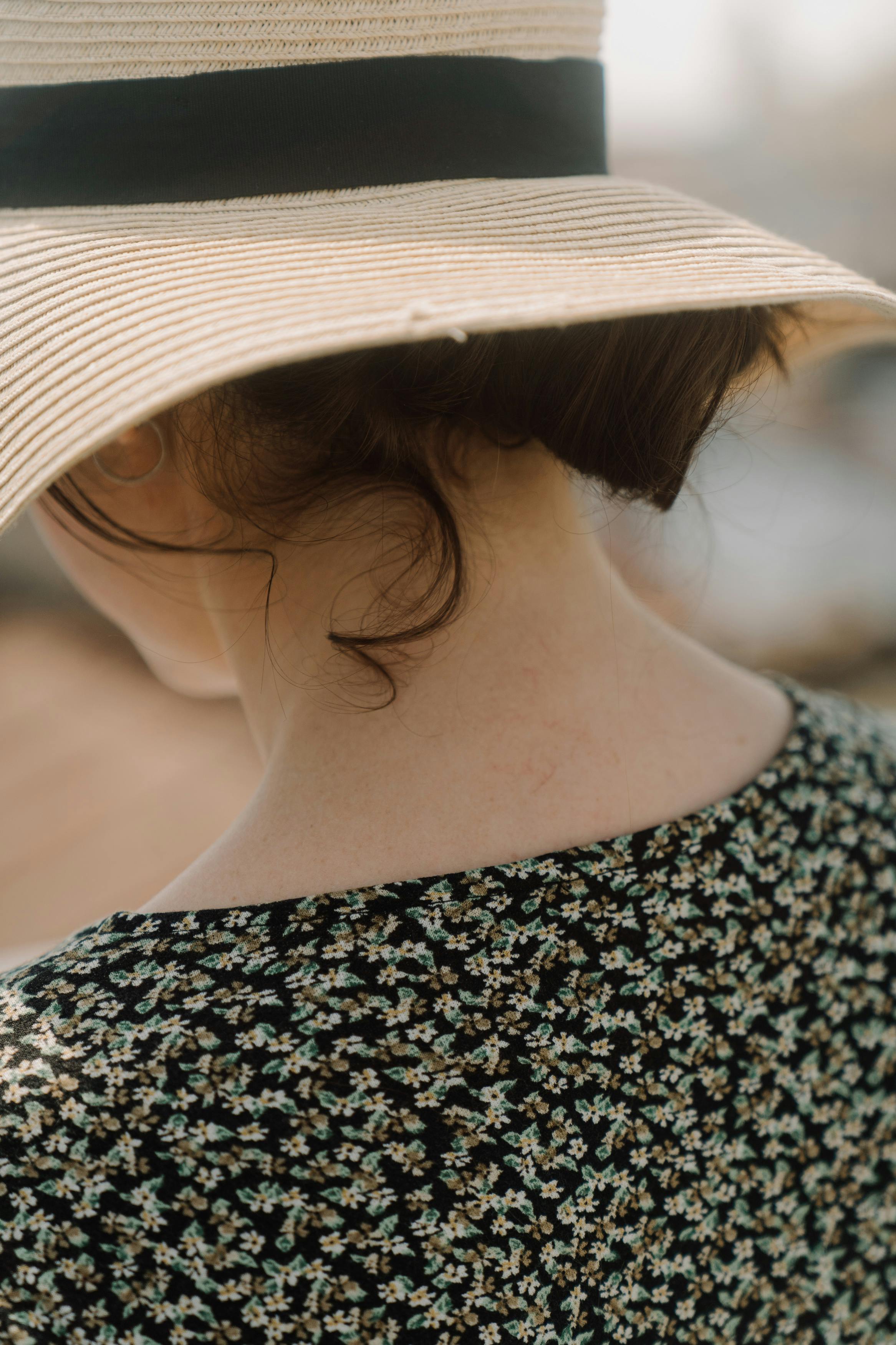 woman in black and white shirt wearing white sun hat