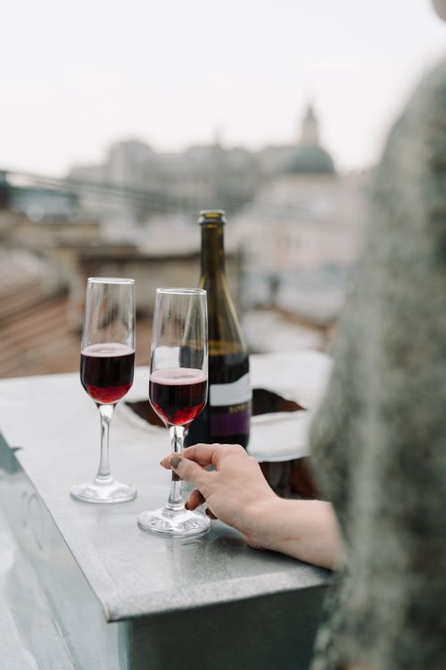 Free Enjoy a romantic evening on a rooftop with wine, capturing a city skyline view in summer. Stock Photo