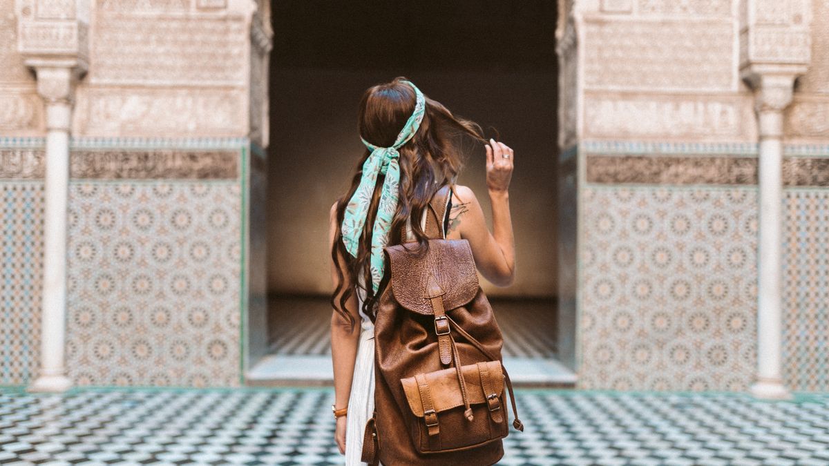 Woman exploring city streets alone with a backpack and camera