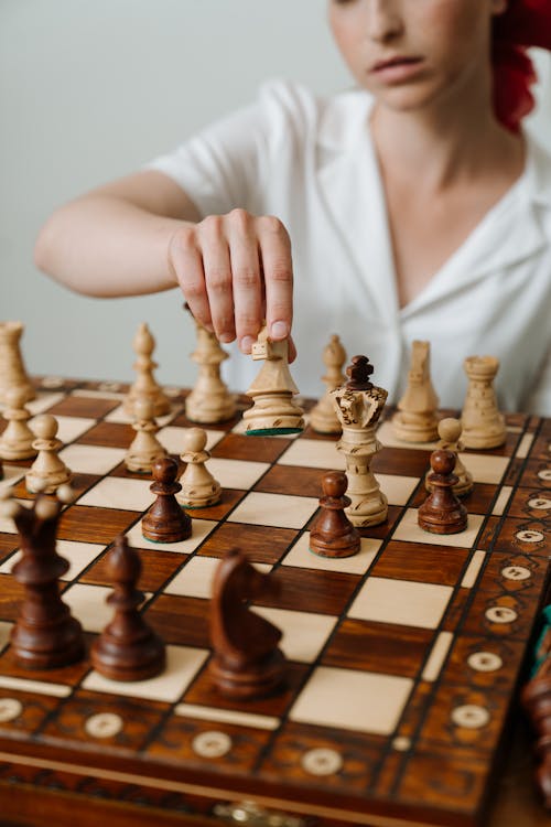 Person Playing Chess Game on Chess Board