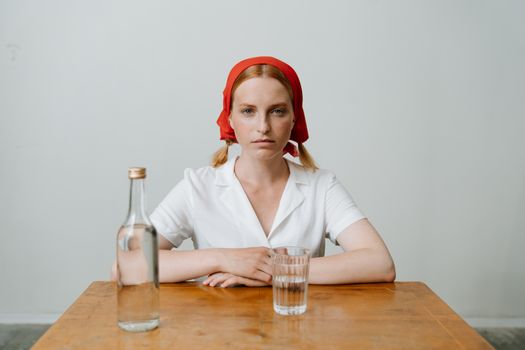 Woman in White Dress Shirt Wearing Red Bandana Sitting Beside Brown Wooden Table