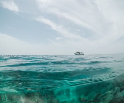 在马尔代夫清澈的水域上，一艘船漂浮在宁静的海景中