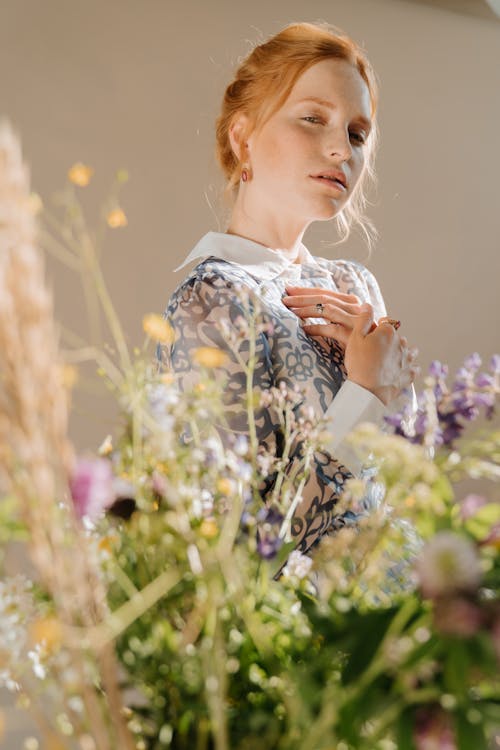 Woman in White and Blue Floral Shirt Holding Her Hair