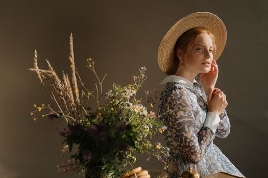 Woman in Brown Sun Hat and Black and White Floral Long Sleeve Shirt Holding Purple Flower