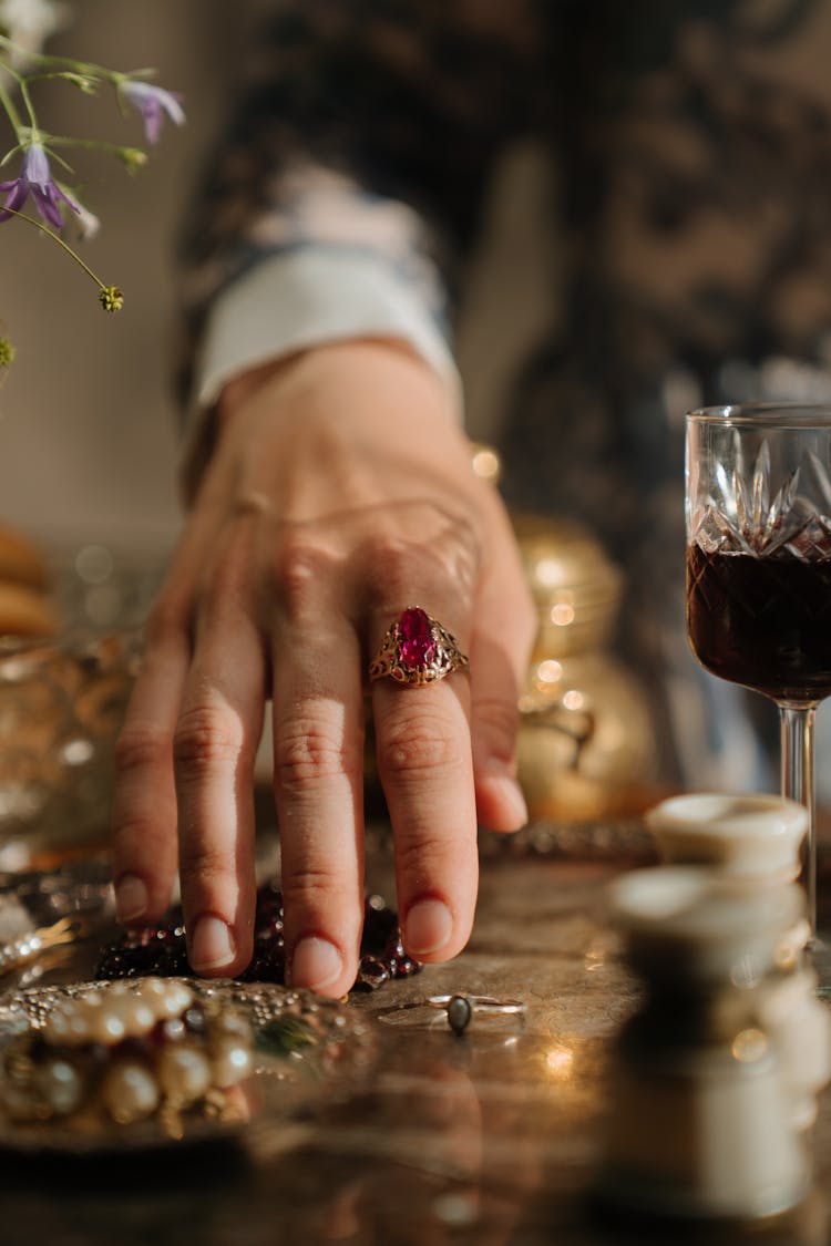 Person Wearing Silver Ring And Red And Gold Ring