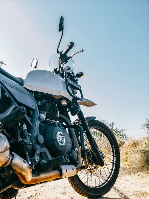 Free Close-up of a classic motorcycle on a sunny dirt road, shot in summer. Stock Photo