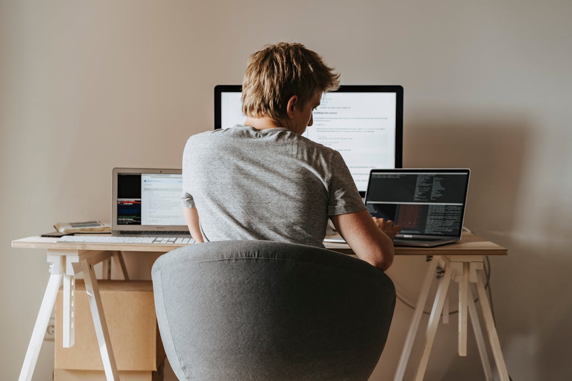 Free Woman in Gray Shirt Sitting on Black Office Rolling Chair Stock Photo