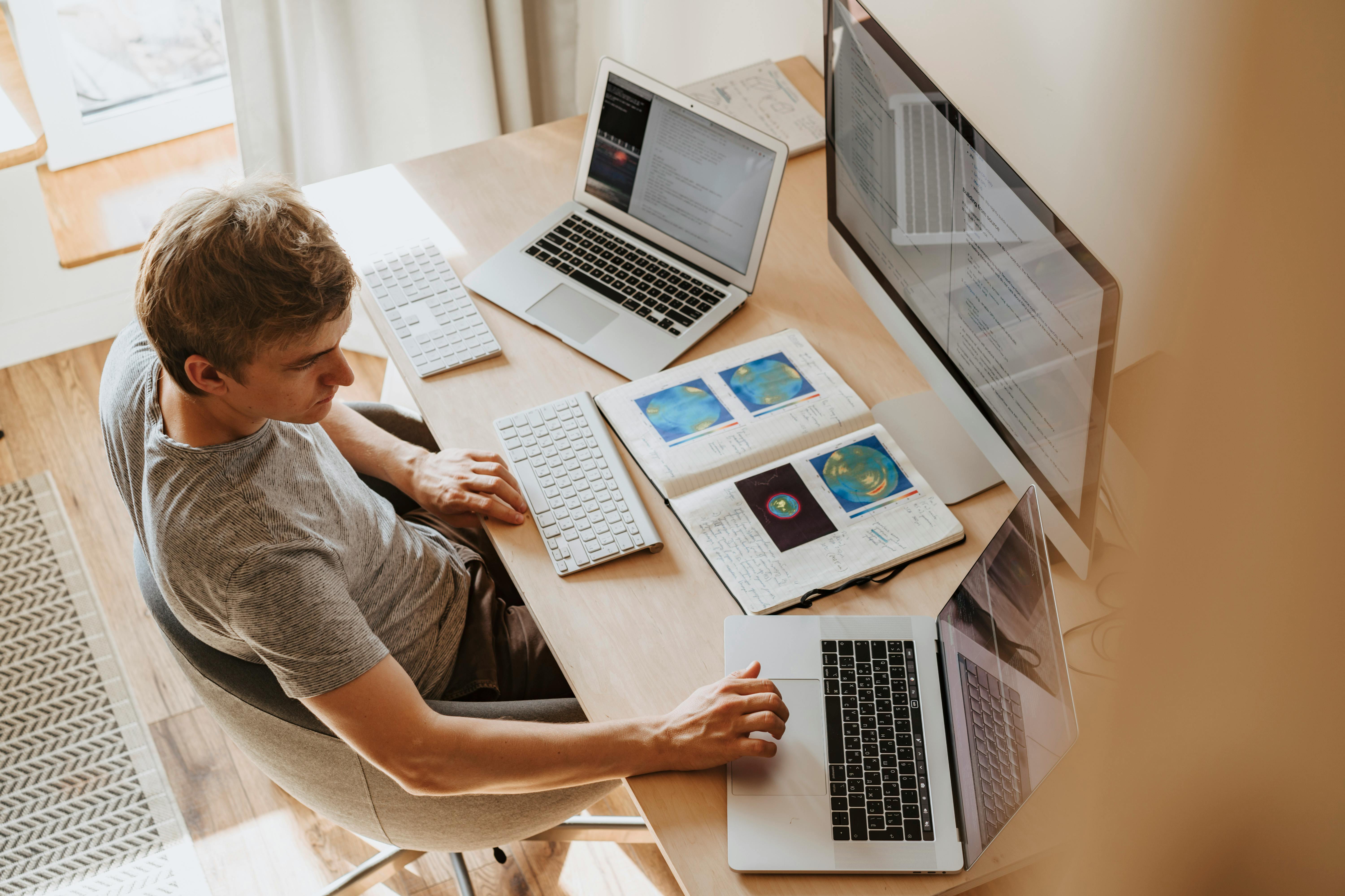 Free Man Using 3 Computers Stock Photo