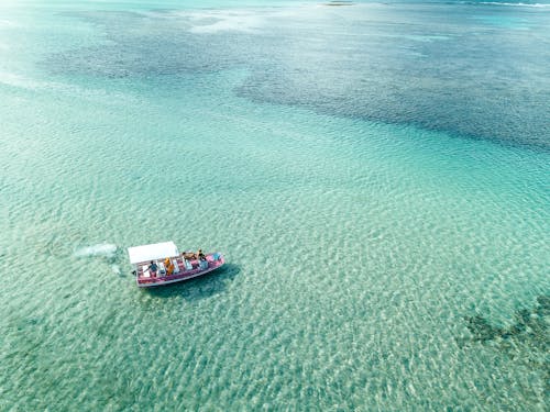 Aerial Photography of a Pink Boat on the Ocean

