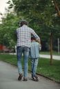 Man in Blue and White Plaid Dress Shirt and Blue Denim Jeans Holding Hands With Woman