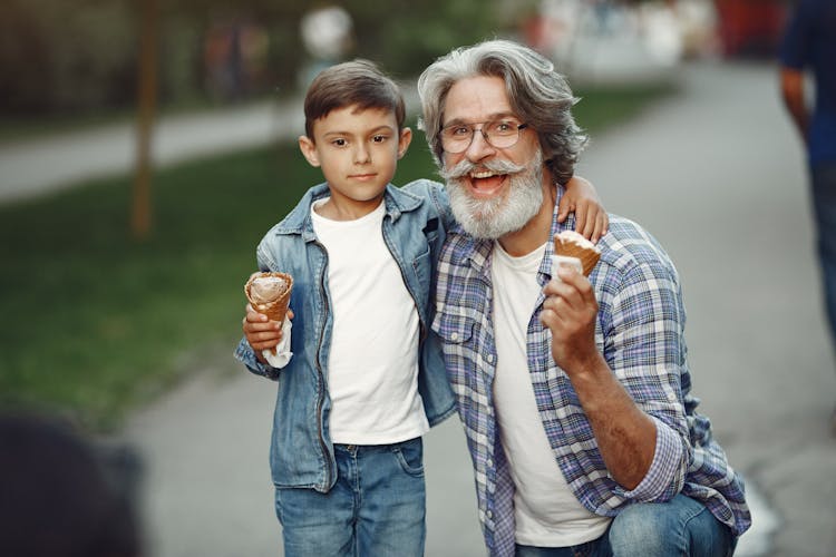 Smiling Elderly Grandfather And Grandson Eating Ice Cream