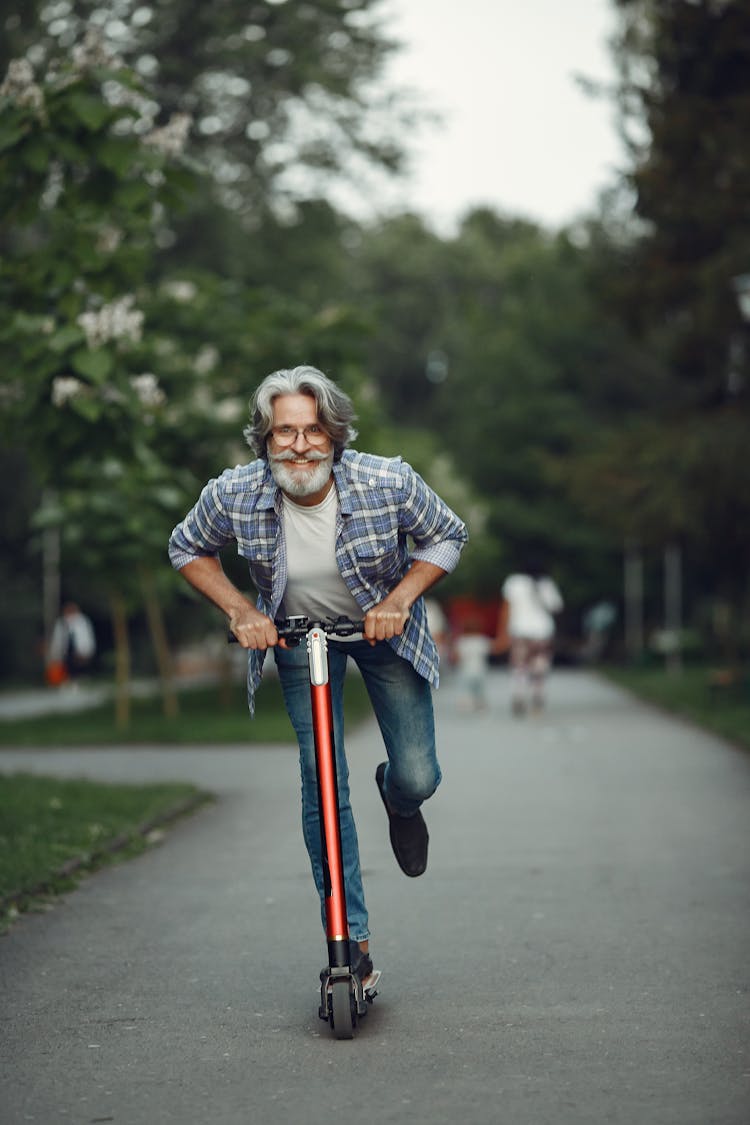 Happy Elderly Man Riding Scooter Outdoors