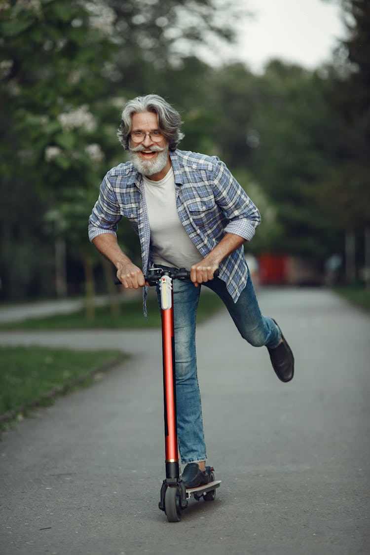 Elderly Man On Scooter On City Street