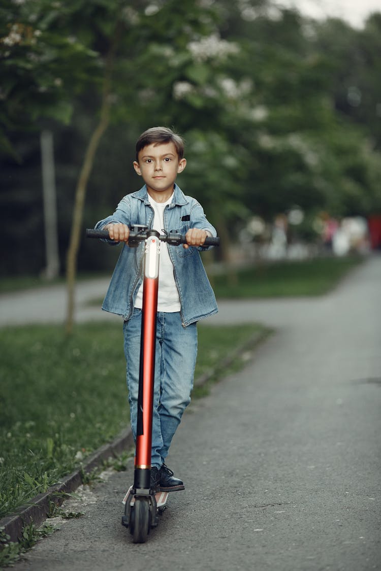 Boy Riding Scooter On Street