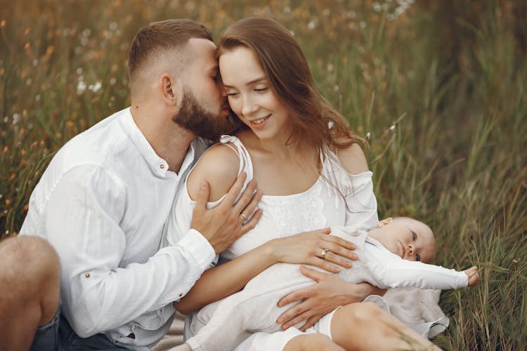 Couple With Baby Kissing