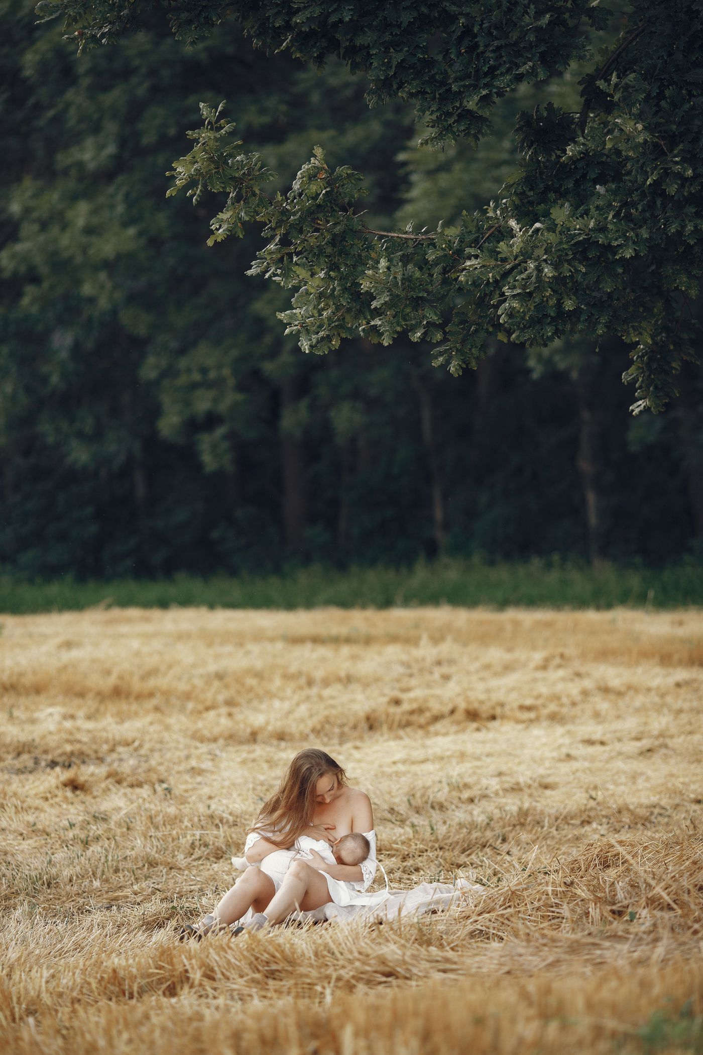 Mother breastfeeding her baby outdoors — lactation, doula and newborn care are among the professional care disciplines ICPCAS accredits