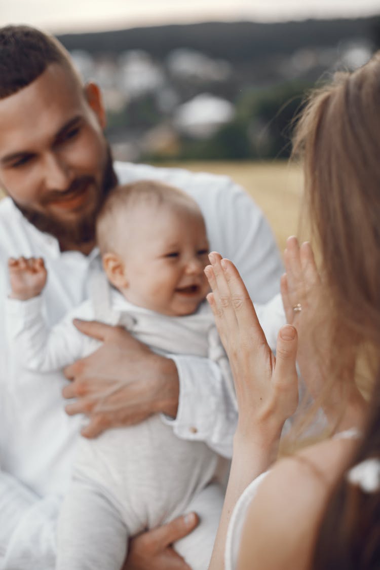 Woman Clapping Her Hands To Make The Baby Laugh 