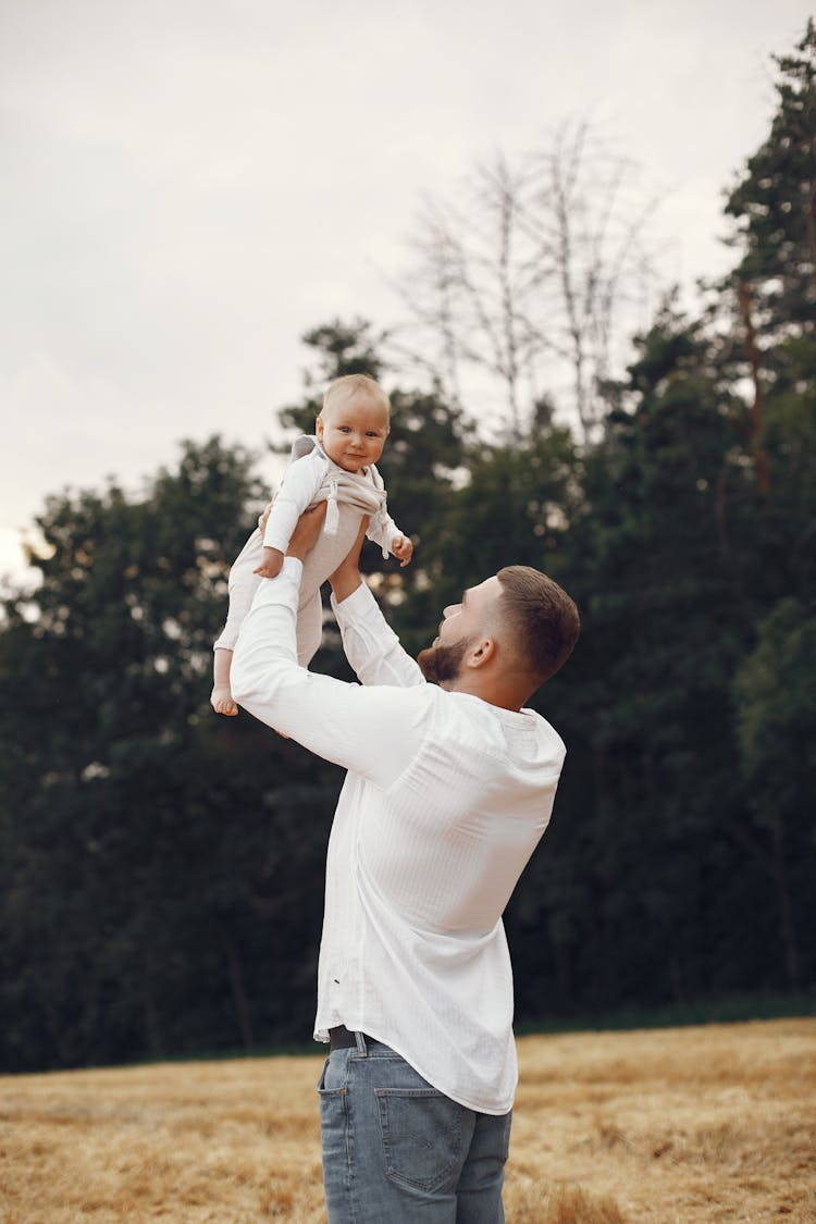 Father Lifting The Baby In The Air 