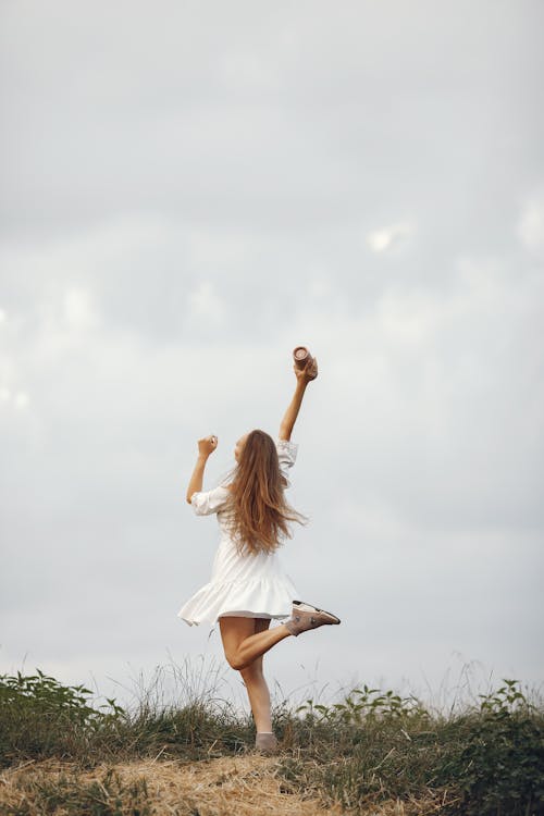 Free Woman in White Dress Dancing Outdoors  Stock Photo