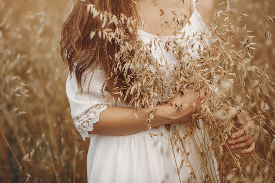 Woman in White Dress Standing Holding Brown Grass Field · Free Stock Photo