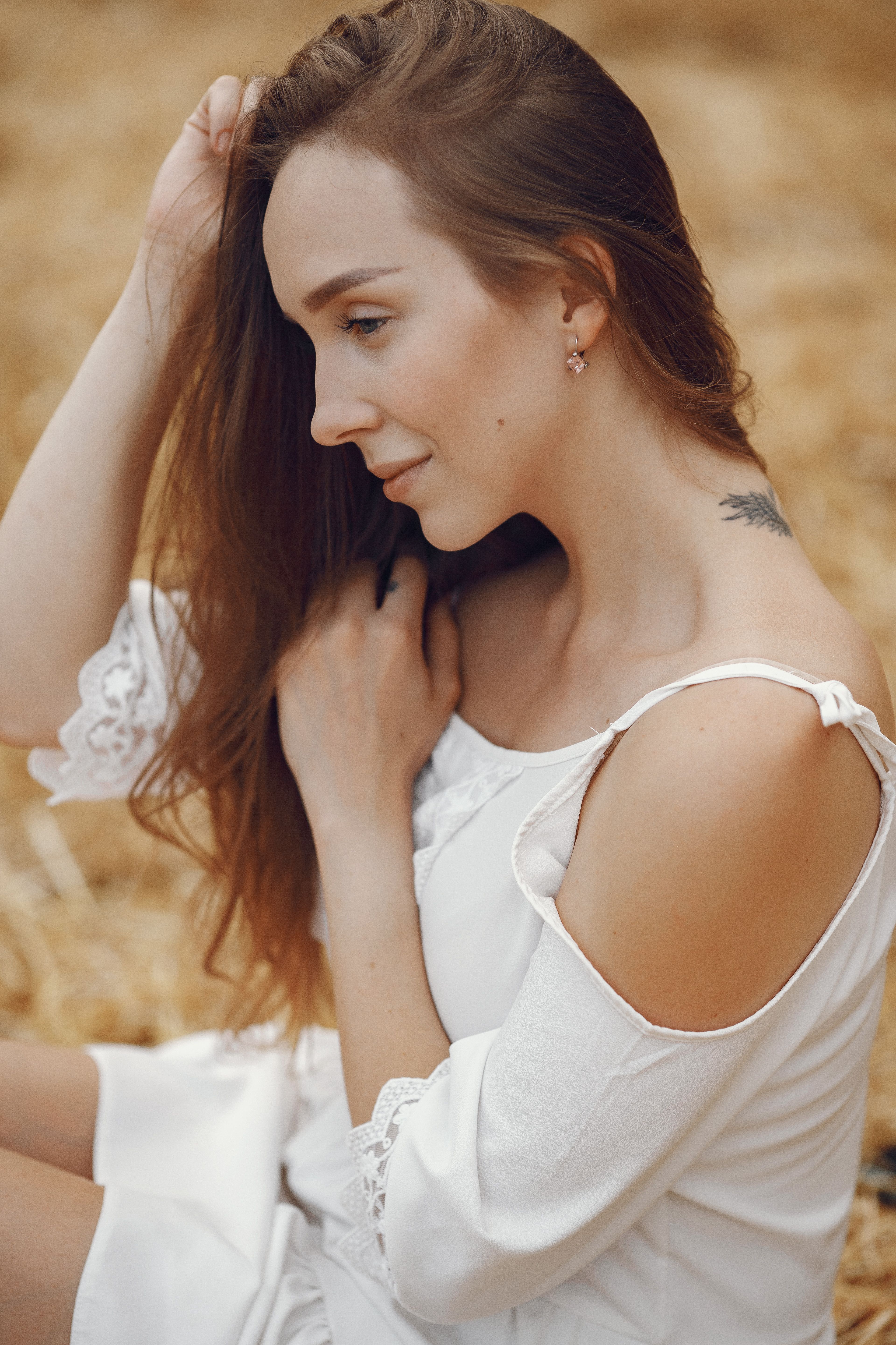 A Woman in White Dress Sitting on the Dry Grass · Free Stock Photo