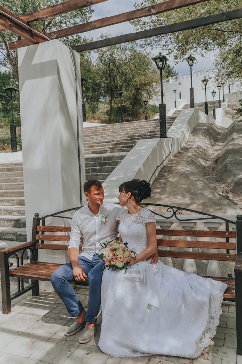 Happy newlywed couple sitting on bench