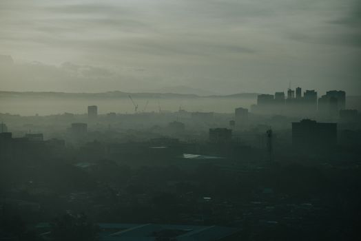 黎明时分，薄雾笼罩着奎松市那变幻莫测的城市景观，展现出一片宁静而富有戏剧性的景象