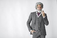 一位穿着定制西装、手持烟斗的杰出长者肖像，背景为白色