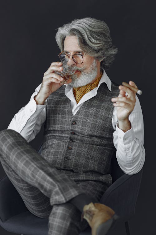 Elderly Elegant Man in Suit Smoking Cigar and Drinking