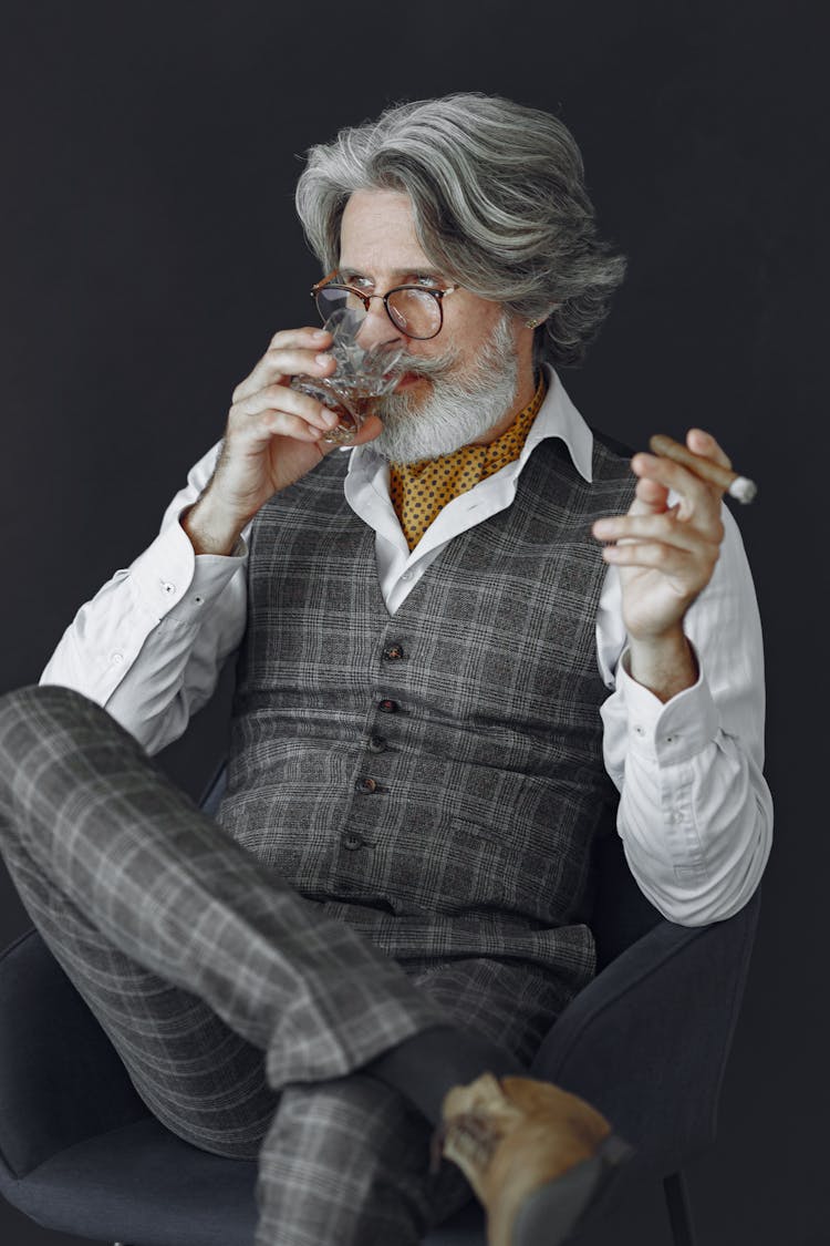 Elderly Elegant Man In Suit Smoking Cigar And Drinking