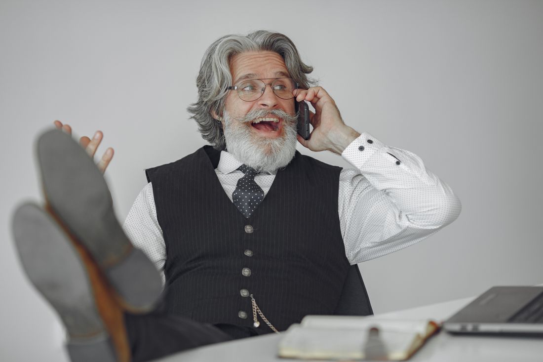Senior man with gray hair talking on the phone and laughing