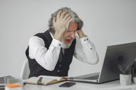 Man in White Dress Shirt Covering His Face With His Hands