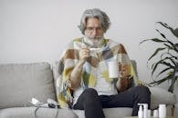 Woman in White and Brown Sweater Holding White Ceramic Mug