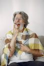 Woman in Yellow White and Blue Stripe Shirt Sitting on Gray Sofa
