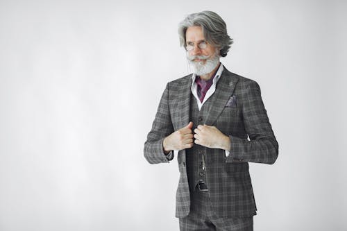 Elderly Man Wearing Gray Plaid Suit on White Background