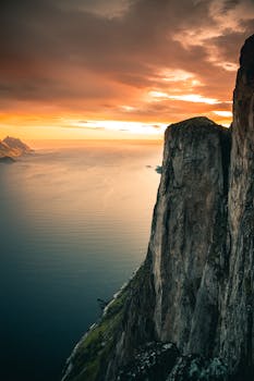A breathtaking view of Norway's rugged coastline at sunset, capturing dramatic cliffs and serene seascape.